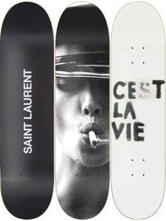 three skateboards with black and white images on them, one has the word get la vie written on it