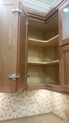 an open cabinet in the corner of a kitchen