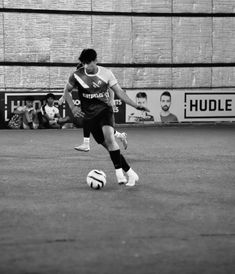 a man kicking a soccer ball on top of a field