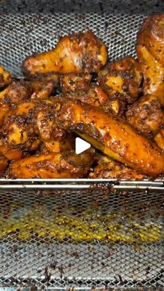 chicken wings cooking in a basket on the grill