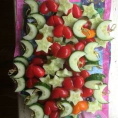 cucumbers, tomatoes, and other vegetables are arranged on a table cloth for display