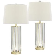 two clear glass table lamps with gold trimmings and white shades on each lamp