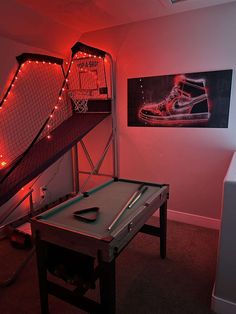 a pool table in front of a staircase with shoes on it and lights hanging from the ceiling