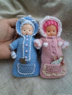 two small crocheted dolls sitting next to each other on top of a blanket