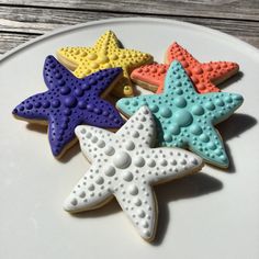 four decorated starfish cookies on a white plate