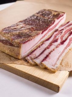 two pieces of meat sitting on top of a cutting board