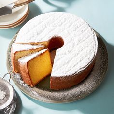 a cake on a plate with one slice cut out and the other half covered in powdered sugar