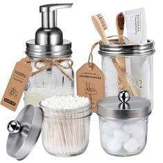 three mason jars with toothbrushes and soap dispensers