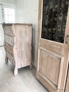 an old wooden cabinet sitting next to a glass fronted cabinet in a room with white walls