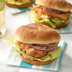 two chicken sandwiches with lettuce and onions on buns