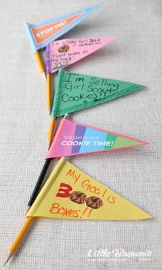 four colorful paper pennants with writing on them