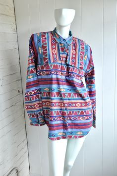 "A fantastic Aztec-style cotton blouse by Adobe Rose. The shirt features unique button / flap details on the front and back, with an open pleat in the back. Made in Hong Kong in 1993. CONDITION: Fantastic, with minor fading and a run or two in the fabric. Near new condition. MEASUREMENTS Bust: 44\" Length: 31\" Have a question? Please ask me anything." Bohemian Long Sleeve Shirt With Buttons, Oversized Cotton Blouse With Buttons, Bohemian Cotton Button-up Shirt, Bohemian Tunic Top With Buttons, Multicolor Cotton Top With Buttons, Multicolor Cotton Tops With Buttons, Multicolor Cotton Blouse With Buttons, Bohemian Festival Tops With Buttons, Bohemian Style Festival Tops With Buttons