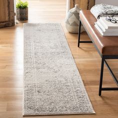 a long white rug on the floor in a room with wooden floors and a bench