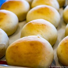 freshly baked bread rolls sitting on a baking sheet ready to be baked in the oven