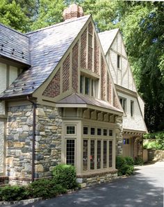 a house with stone and shingles on the roof