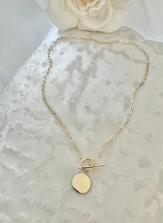 (Photo Enlarge To Show Detail)✨ Elevate your style with our 14K Yellow Gold Paperclip Disc Necklace. This exquisite piece features a sleek, real gold chain, measuring 18 inches in length, that perfectly complements its modern paperclip design. The disc pendant offers a touch of elegance and can be engraved to create a personalized keepsake. Secure and stylish, the toggle lock adds both functionality and flair. Crafted with genuine 14K yellow gold, this necklace is designed for women who appreciate quality and sophistication. Perfect for any occasion, it's a timeless addition to your jewelry collection. 🌟 💫 Uncover the perfect fusion of trendiness and resilience with our 14k Gold Paperclip Disc Necklace. This necklace effortlessly complements your daily attire. Wear it solo to exude elega Real Gold Chains, Paperclip Necklace, Toggle Necklace, Disc Pendant, Layered Jewelry, Disc Necklace, Wedding Jewellery Necklace, Minimalist Necklace, Fine Jewellery Necklace