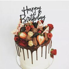 a birthday cake decorated with strawberries and chocolate