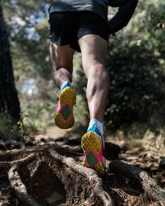 a man running on a trail in the woods with his feet up and shoes down