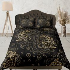 a black and gold comforter set with dragon designs on it, along with two lamps