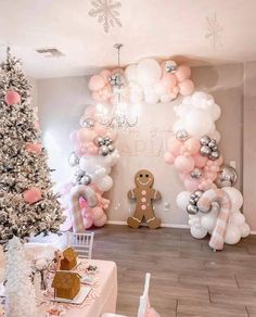 a decorated christmas tree in front of a wall with balloons and gingerbreads on it