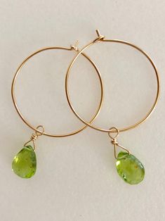 "Lovely apple green genuine peridot pear drops wire wrapped on delicate 1\" 14k gold hoops. Petite faceted peridot briolettes are 7 x 10mm and hang from handmade 1\" 14k gold fill wire hoops. Total drop length is 1 3/4\". Also available in Sterling silver. A lovely sparkly August birthday gift!" Green Peridot Wire Wrapped Jewelry, Teardrop Peridot Jewelry For May Birthstone, Teardrop Peridot Birthstone Jewelry, Green Briolette Jewelry With Ear Wire, Green Briolette Wire Wrapped Jewelry, Yellow Gold Peridot Teardrop Jewelry, August Birthday, Aquamarine Earrings, August Birthstone