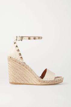 If you're someone who lives in heels - even on your days off - Valentino Garavani's espadrille sandals are just the thing to pack for your next vacation. Set on jute platform wedges, they're made from textured-leather that's hand-embellished with glistening 'Rockstuds'. The cream hue will look so lovely with pastels. Espadrille Wedge Sandals, Luxury Must Haves, Valentino Wedges, Brown High Heels, Wedge Espadrilles, Studded Heels, Ankle Strap Wedges, Black Espadrilles, Leather Espadrilles