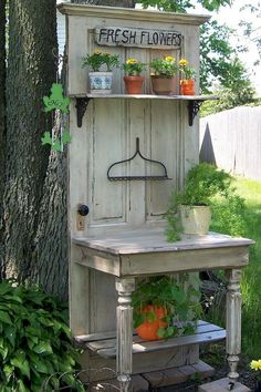 an old wooden cabinet with potted plants on top and a sign that says fresh flowers above it