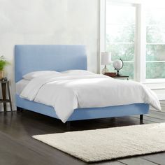 a blue bed with white sheets and pillows