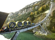 a roller coaster going across a bridge over water