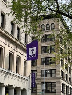 a tall building with a purple flag hanging from it's side