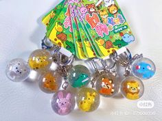 a bunch of key chains that are on top of a white table with an animal book