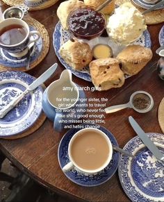 a table topped with blue and white plates filled with pastries next to cups of coffee