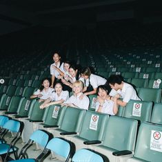 a group of people sitting in the middle of a row of empty seats at a stadium