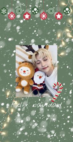 a young boy holding a teddy bear in front of christmas decorations and snowflakes