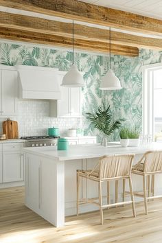 a kitchen with white cabinets and green wallpaper, two chairs at the center island