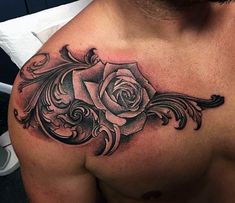 a man's chest with a rose tattoo design on the top half of his chest