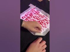 a person holding a piece of cake with red icing on it