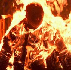 a firefighter in full gear walking through the flames