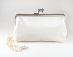 "Soft Ivory velvet clutch, the inside is solid ivory 100% cotton (not waterproof). Handy pocket inside holds business cards, ID and credit cards. The purse is large enough to hold sunglasses, cell phones, pens, compacts...everything you need for a night out! Choose your metal purse frame finish: silver (pictured), rose gold or gunmetal (antique bronze not pictured but available upon request) Dimensions: 8\" wide metal frame on top, 8.75\" wide at the bottom, 3\" deep x 5\" tall Inside pocket mea Classic Cream Evening Clutch, Classic White Wedding Bag, Elegant Clutch Bag For Bridesmaid Gift, Classic Clutch Evening Bag For Wedding, Classic Clutch Bags For Wedding, Classic Wedding Clutch Bag, Chic Cream Wedding Clutch, Elegant Rectangular Bag For Bridesmaid Gift, Elegant Rectangular Bridesmaid Gift Bag