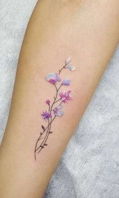 a small flower tattoo on the arm