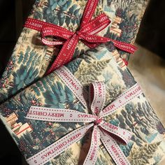 two wrapped presents with red ribbons on them