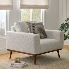 a living room scene with focus on the chair and window coverings that are open