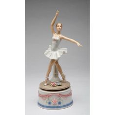 a figurine of a ballerina on top of a pedestal with her arms in the air