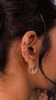 a close up of a person with ear piercings on their ears and behind the ear