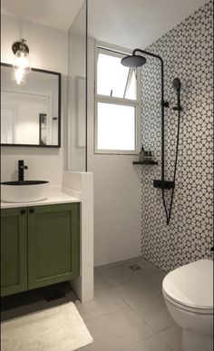 a white toilet sitting next to a green cabinet in a bathroom under a window with a skylight