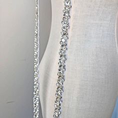 a white mannequin with a silver necklace on it's neck and back