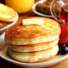 pancakes with butter, syrup and fruit on a plate