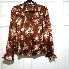 New Calligraphie Brown Floral Blouse Ruffled Sleeve Women's Size Small No Rips Stains Or Flaws. A3 Brown Long Sleeve Floral Print Tops, Brown Floral Print Long Sleeve Tops, Patterned Long Sleeve Top With Ruffles, Fitted Brown Blouse With Floral Print, Fitted Brown Floral Print Blouse, Elegant Brown Tops With Floral Print, Elegant Brown Floral Print Top, Feminine Brown Tops For Fall, Trendy Brown Spring Blouse