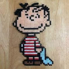 an image of a cartoon character made out of perler beads on a wooden surface