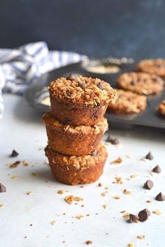 chocolate chip muffins stacked on top of each other in front of a baking tray